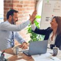 Two colleagues at the office giving five to each other