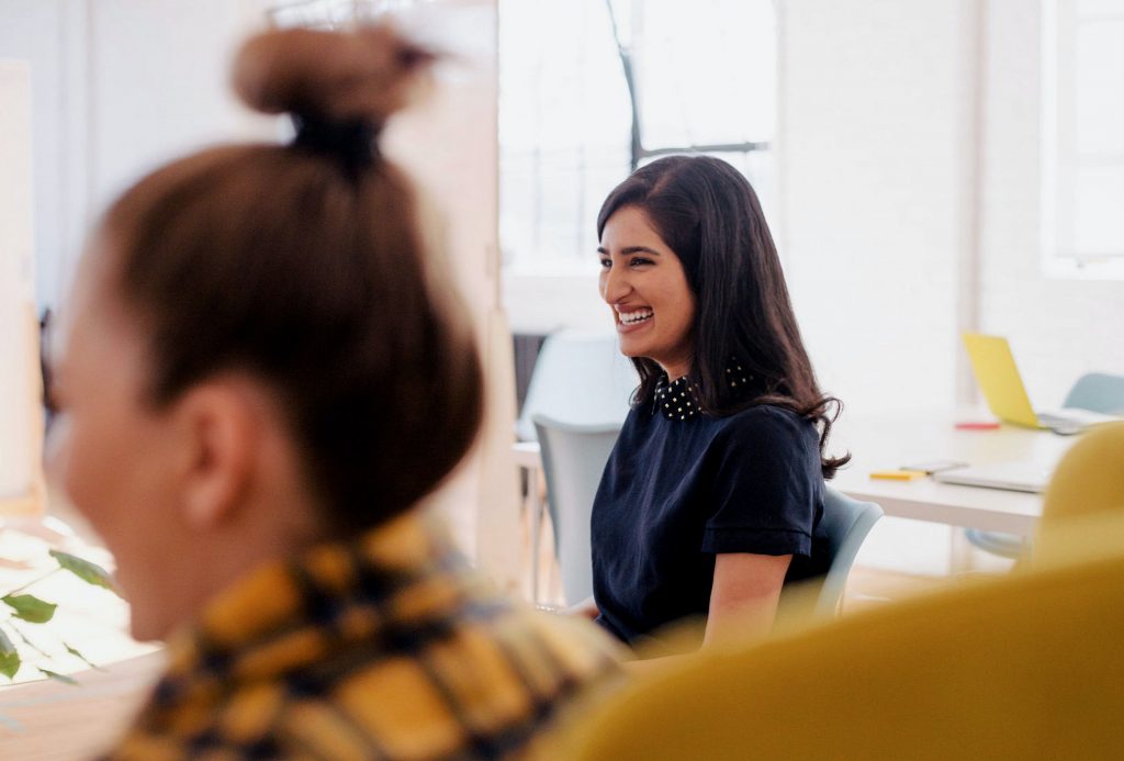 Employee smiling after receiving recognition from their colleagues during a company culture meeting