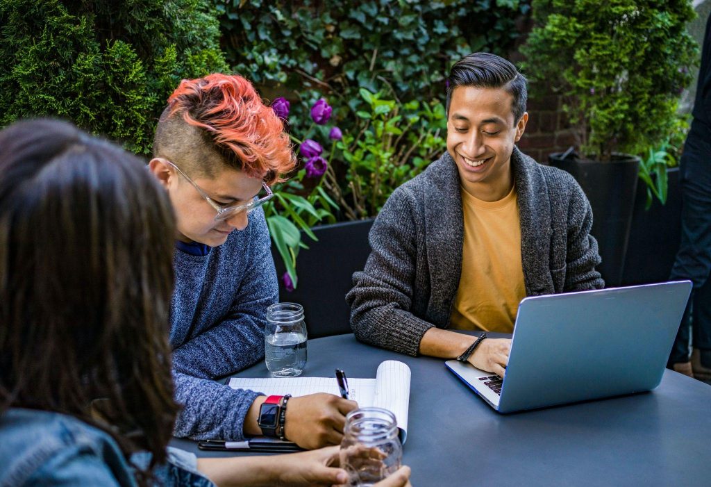 3 diverse employees have a meeting outside the office.