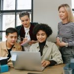 4 colleagues at the office working with the same computer