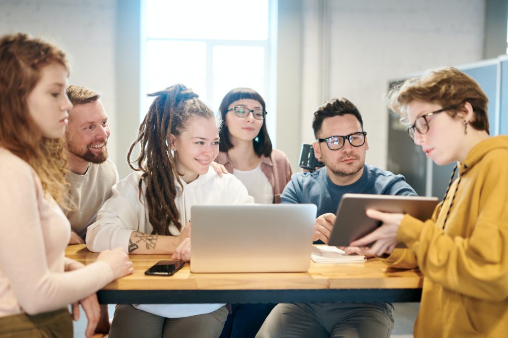 6 employees have a meeting with a tablet and a laptop.