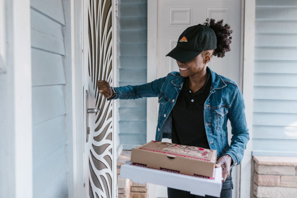 Delivery person delivering food at someone's door.