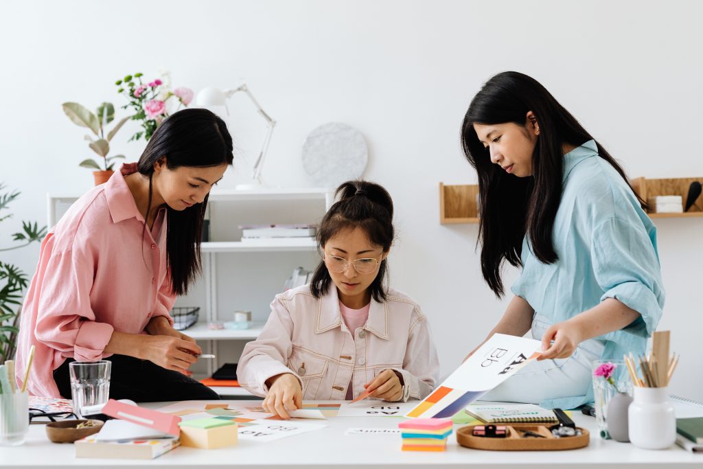 3 employees examine some papers at the office.