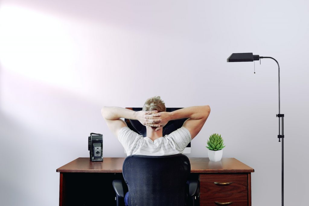 Man holding his head working remotely from his home