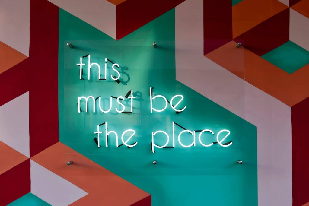 A neon sign with the text: "This must be the place"