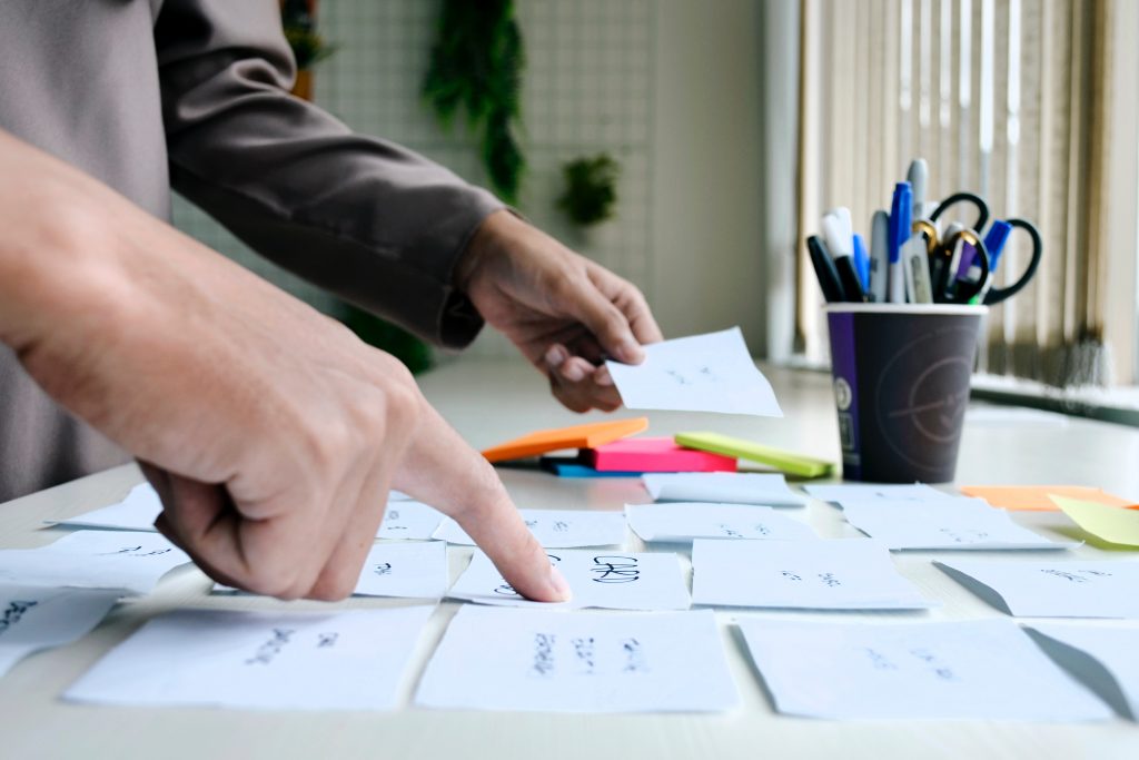 Cards on the table and two people pointing at them, carrying out a dynamic for learning