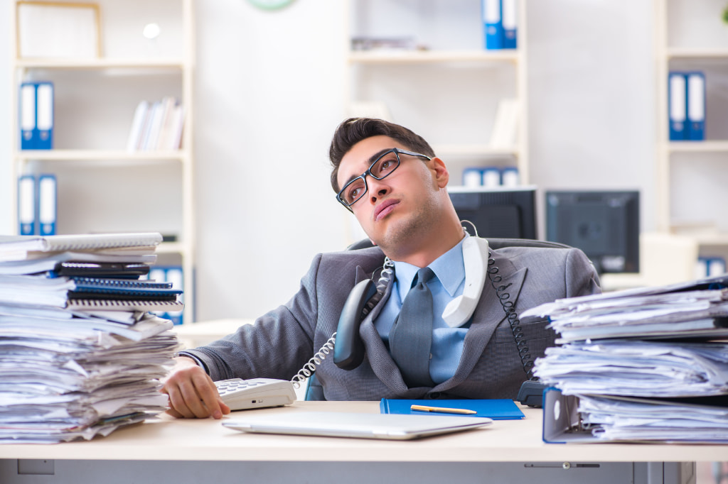 Un empleado cansado en el trabajo. Con síndrome de burnout que derivará en rotación.